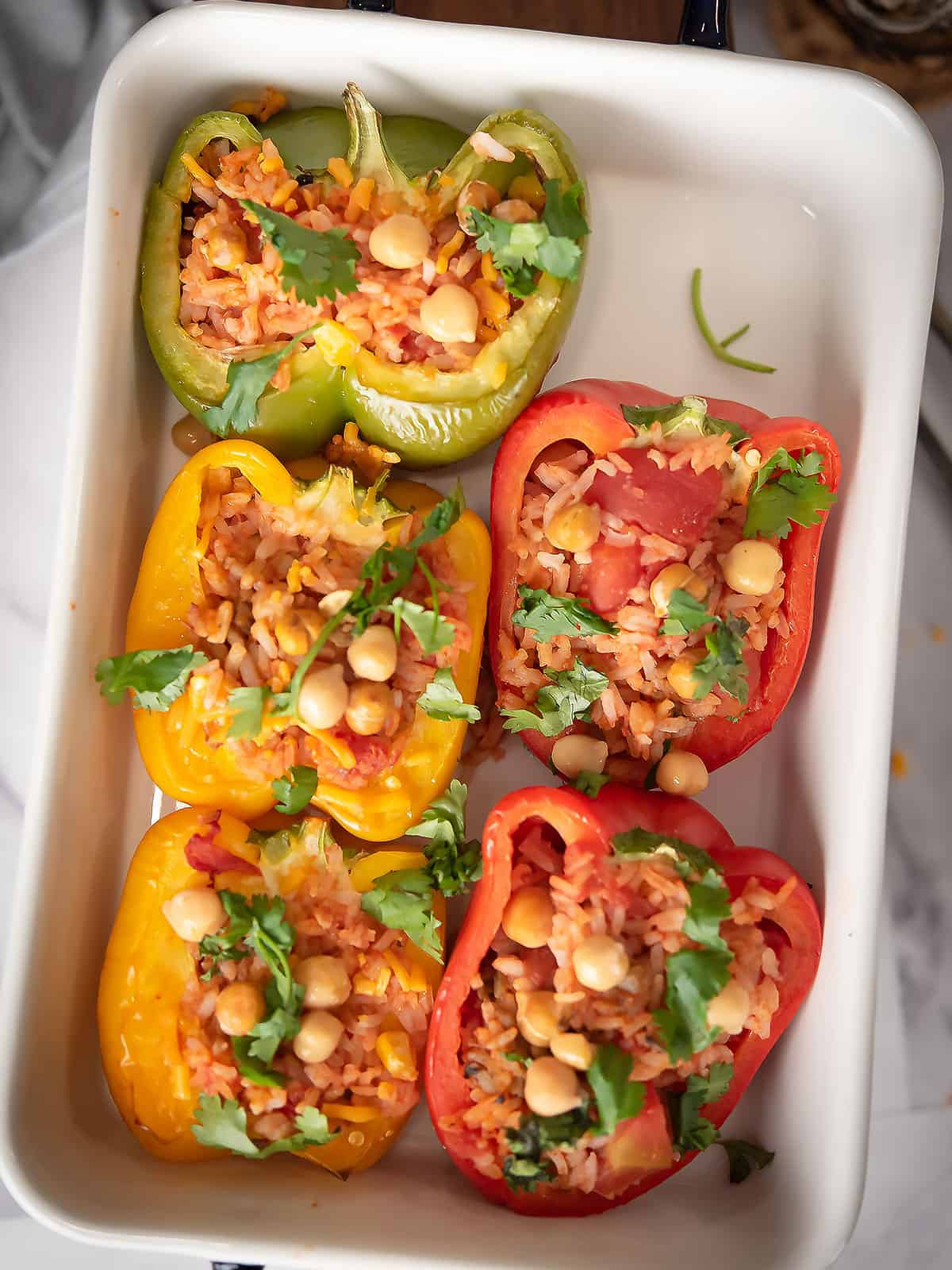 Filling the bell peppers with the chickpea mixture in a baking tray
