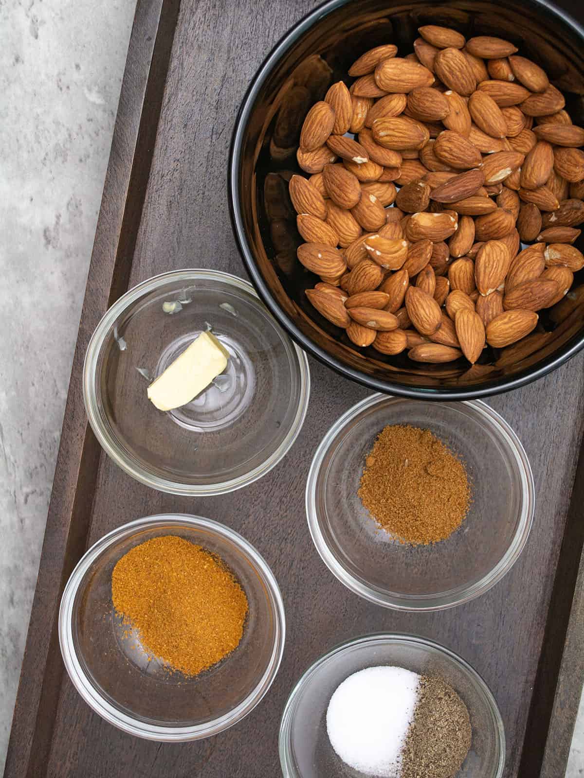 Ingredients for curried almonds: almonds, butter, curry powder, cumin, salt, and pepper.
