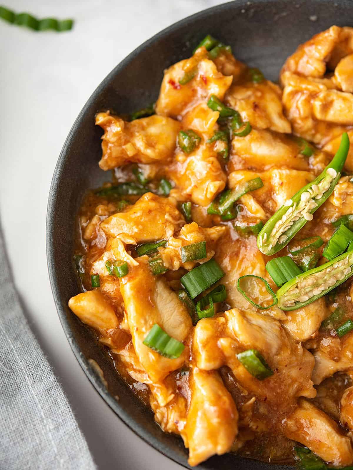 Ingredients for hot and spicy Chinese chicken, including chicken, soy sauce, and chili garlic sauce.