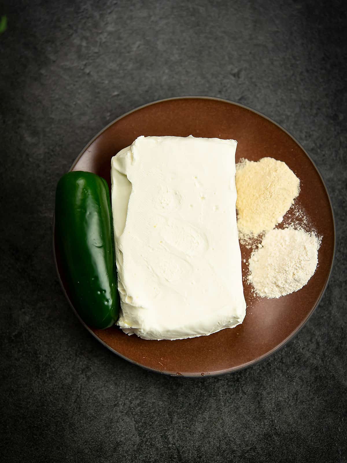 Ingredients for jalapeno cream cheese dip including cream cheese and jalapeno.