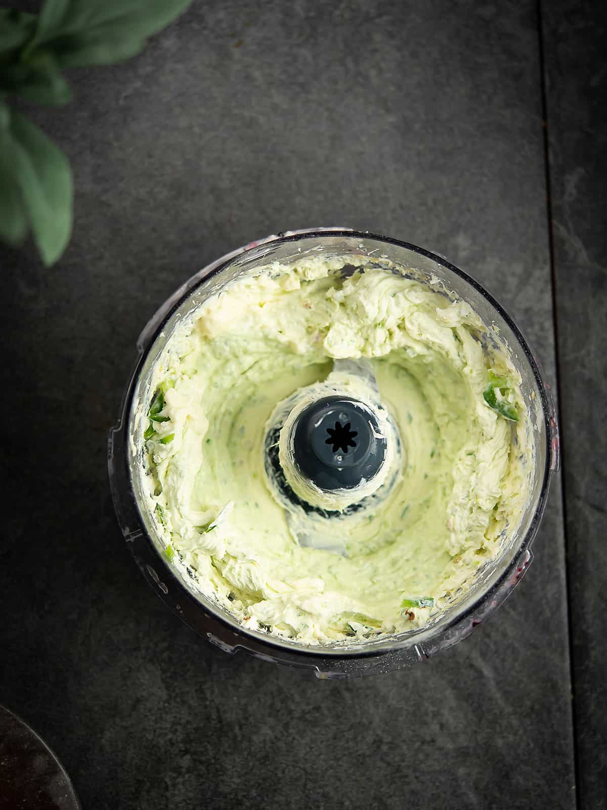 Blending cream cheese and spices in a food processor.