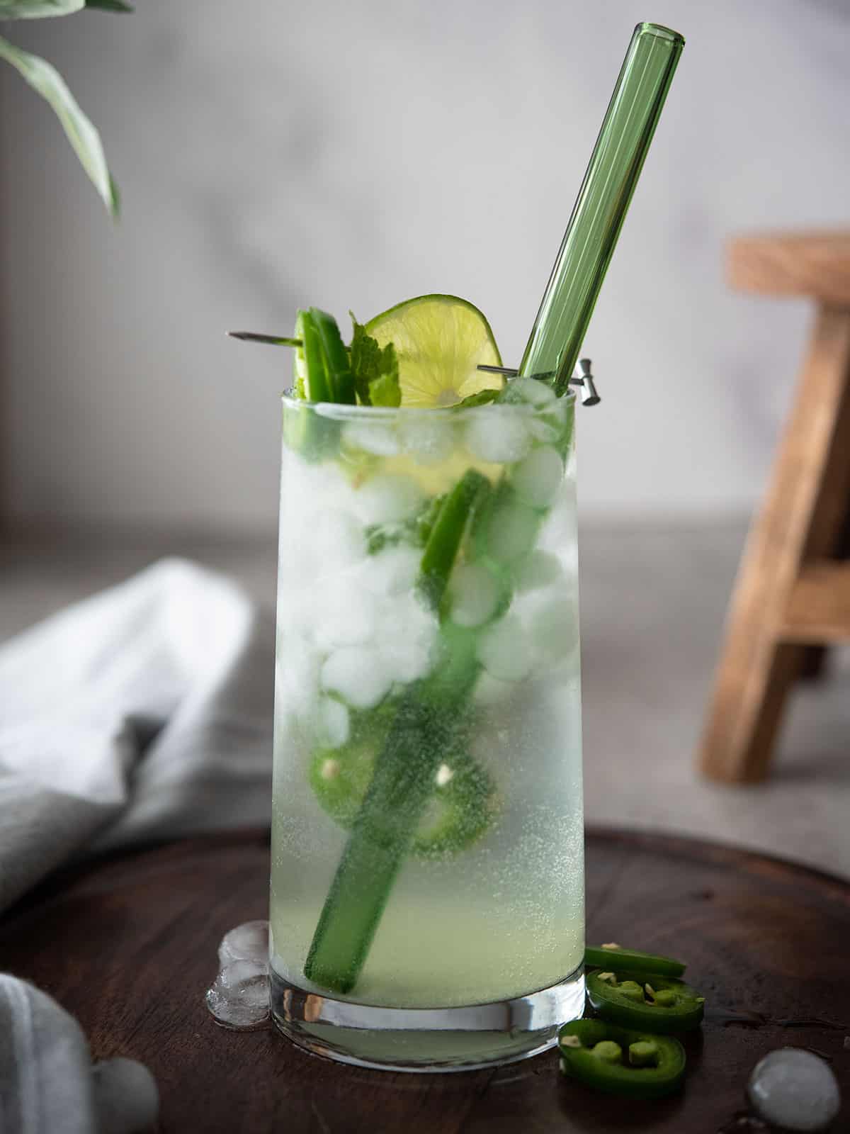 A refreshing glass of jalapeno mojito garnished with mint leaves and lime slices.