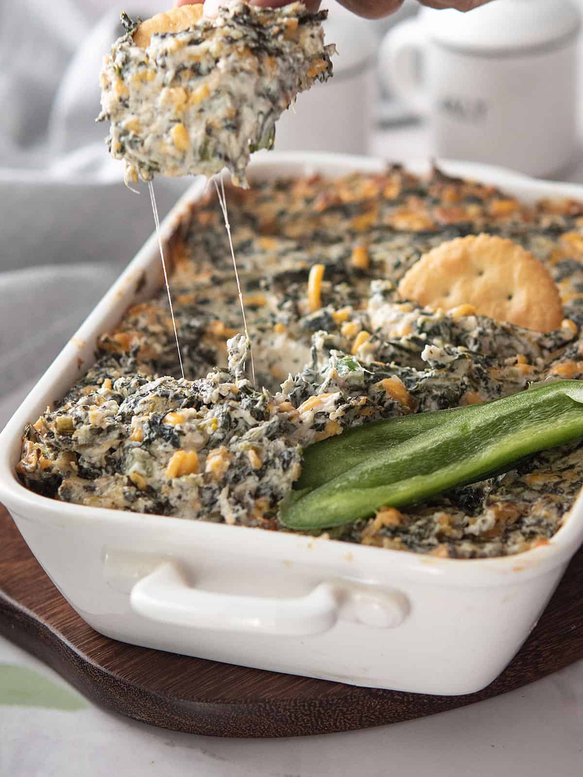 Close-up of cheesey jalapeno spinach dip with a cracker