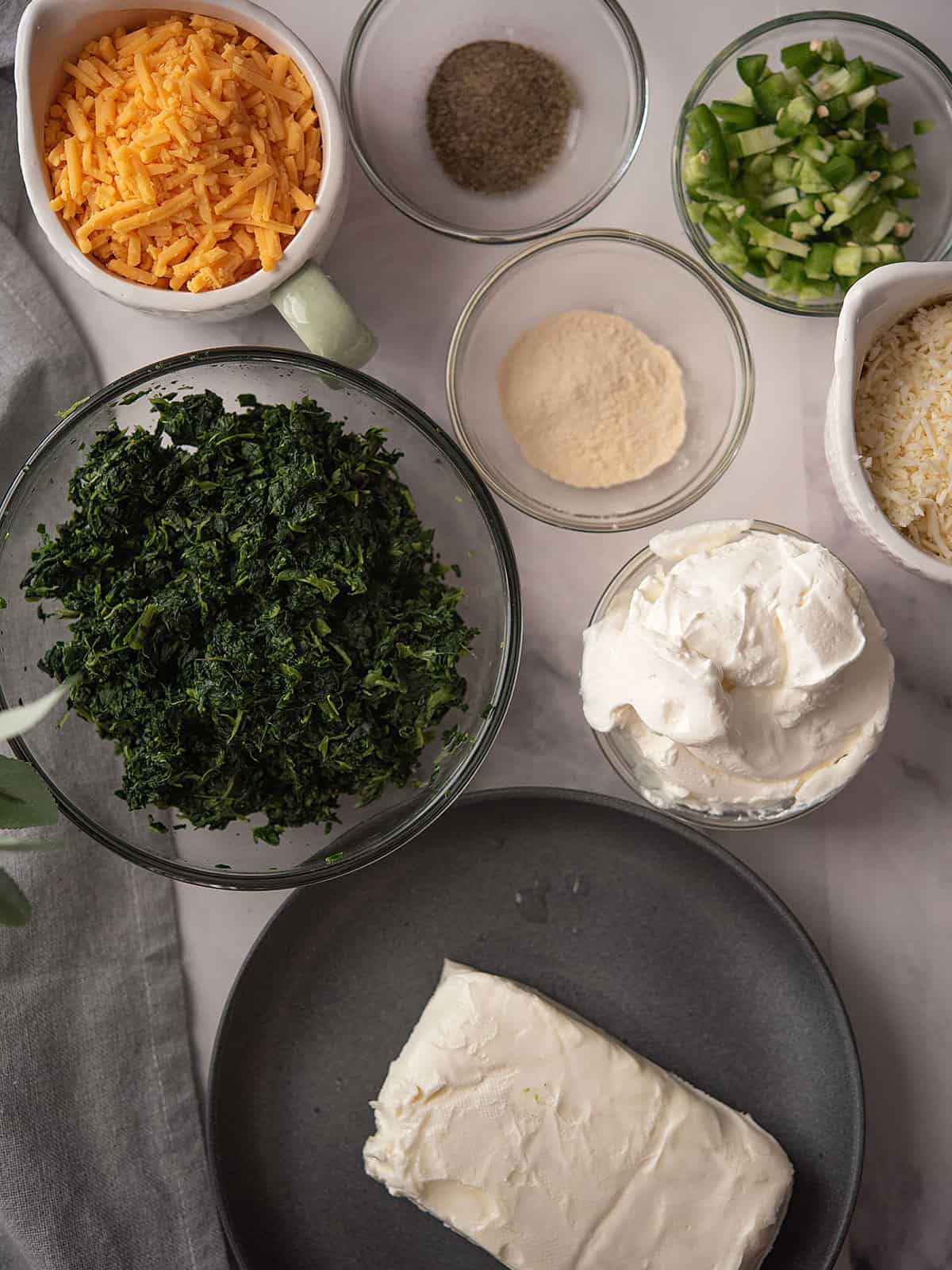 Ingredients for jalapeno spinach dip, including spinach, jalapeno, and cheese.