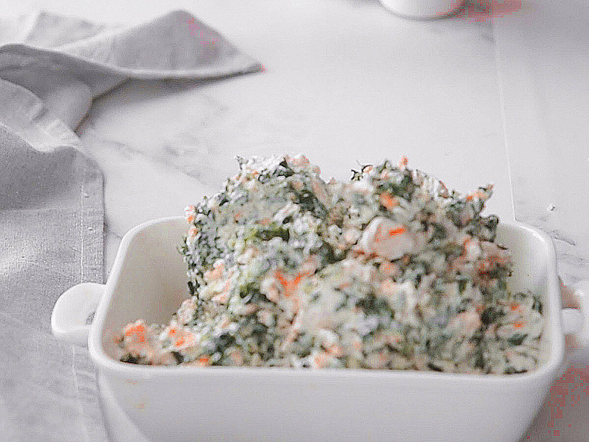 Spinach mixture being transferred into a baking dish.