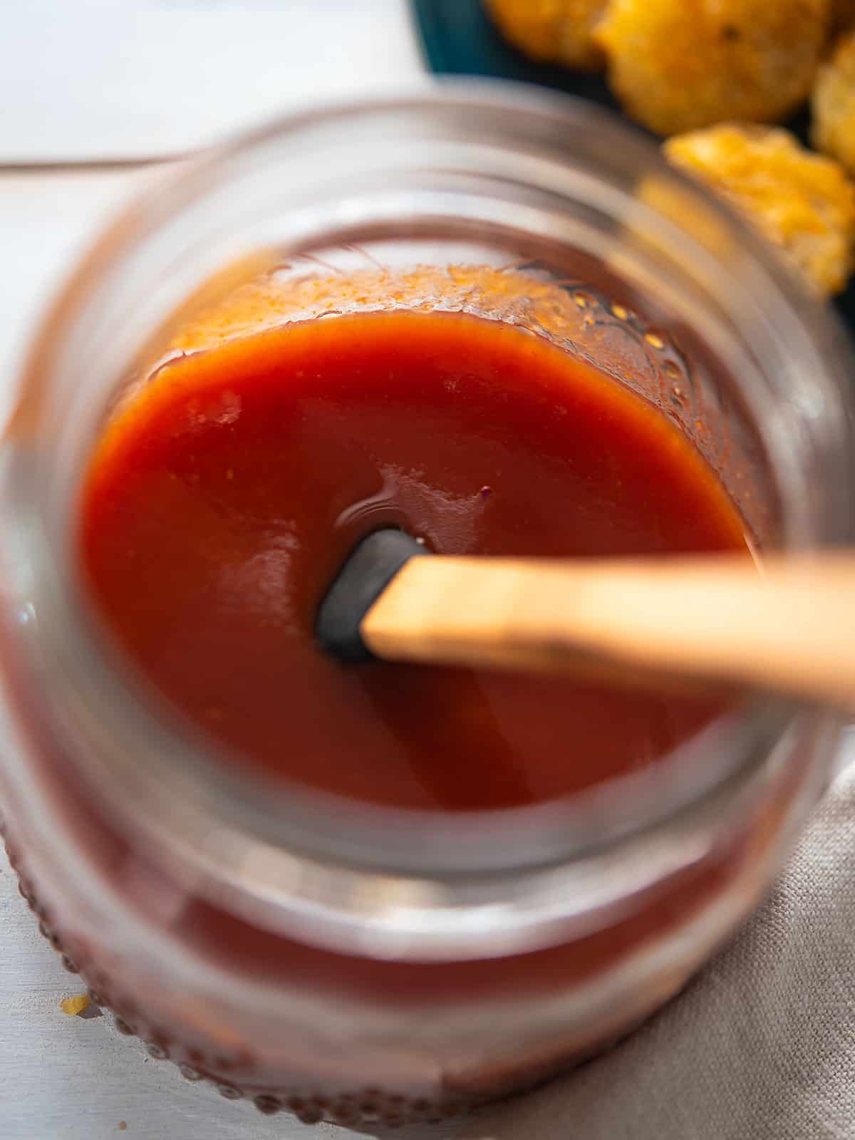 Creamy red ranch sauce in a clear glass jar