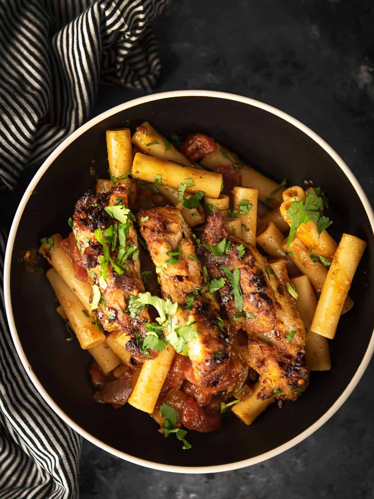 Close-up of creamy chicken pasta with chunks of chicken and colorful peppers