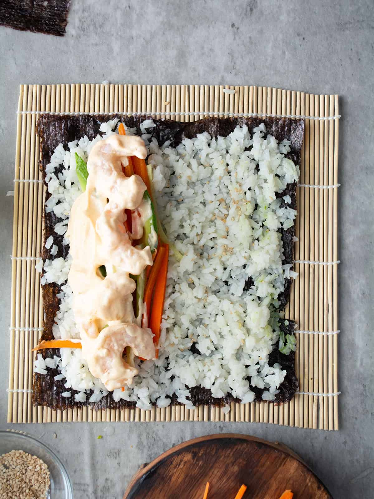 arranging the sushi with shrimp and vegetables inside.