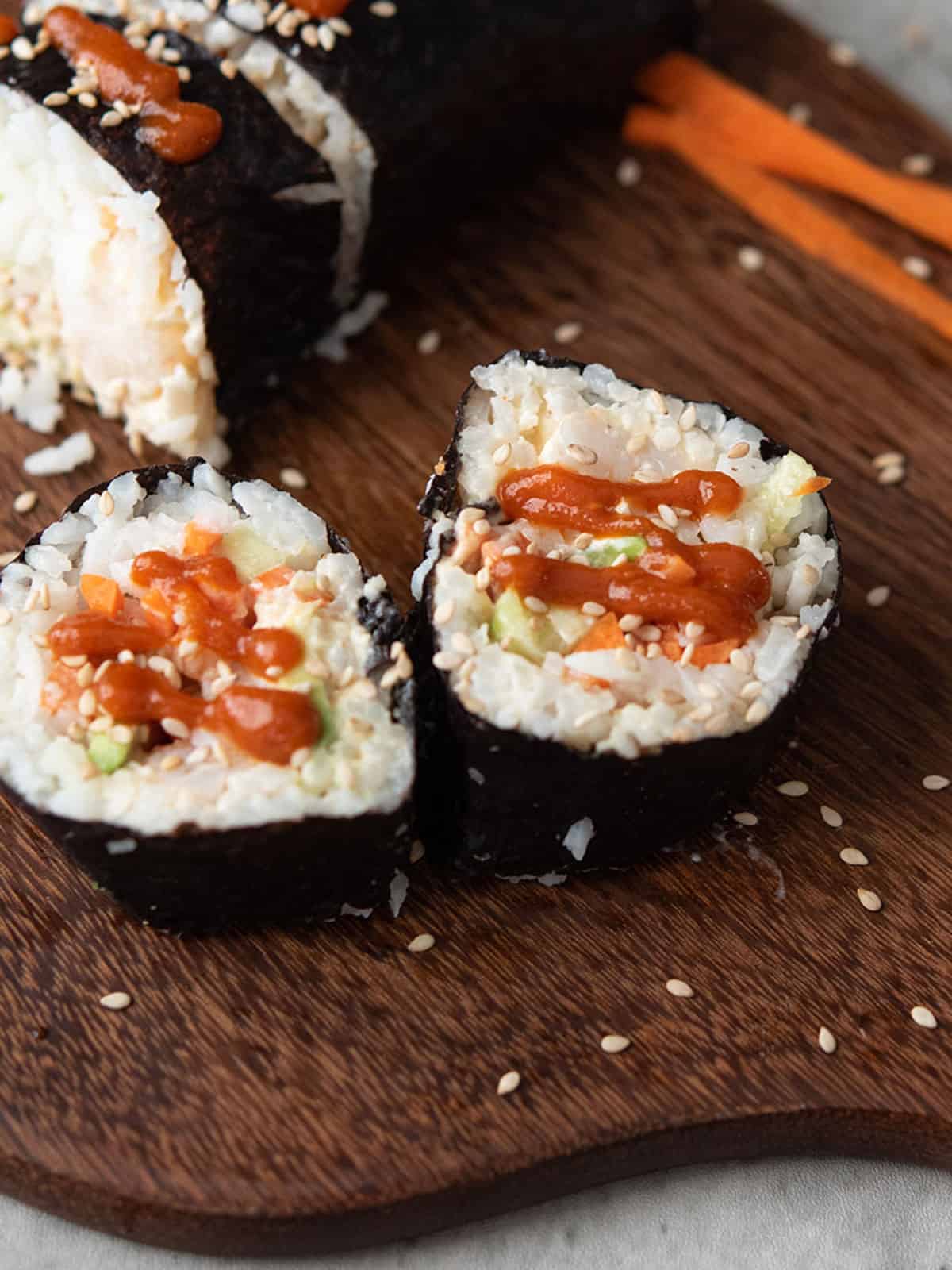 Close-up of spicy shrimp rolls garnished with fresh ingredients.