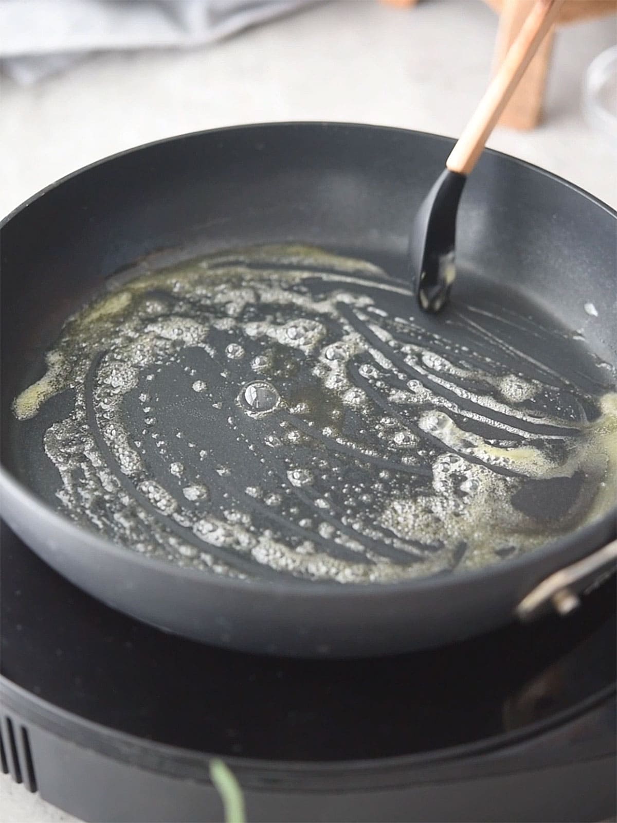 Butter melting in a skillet over medium heat.