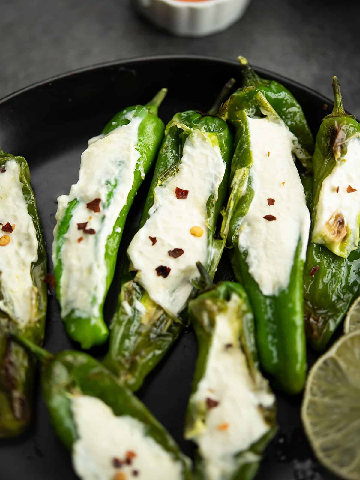 Plate of baked stuffed Shishito peppers ready to eat.