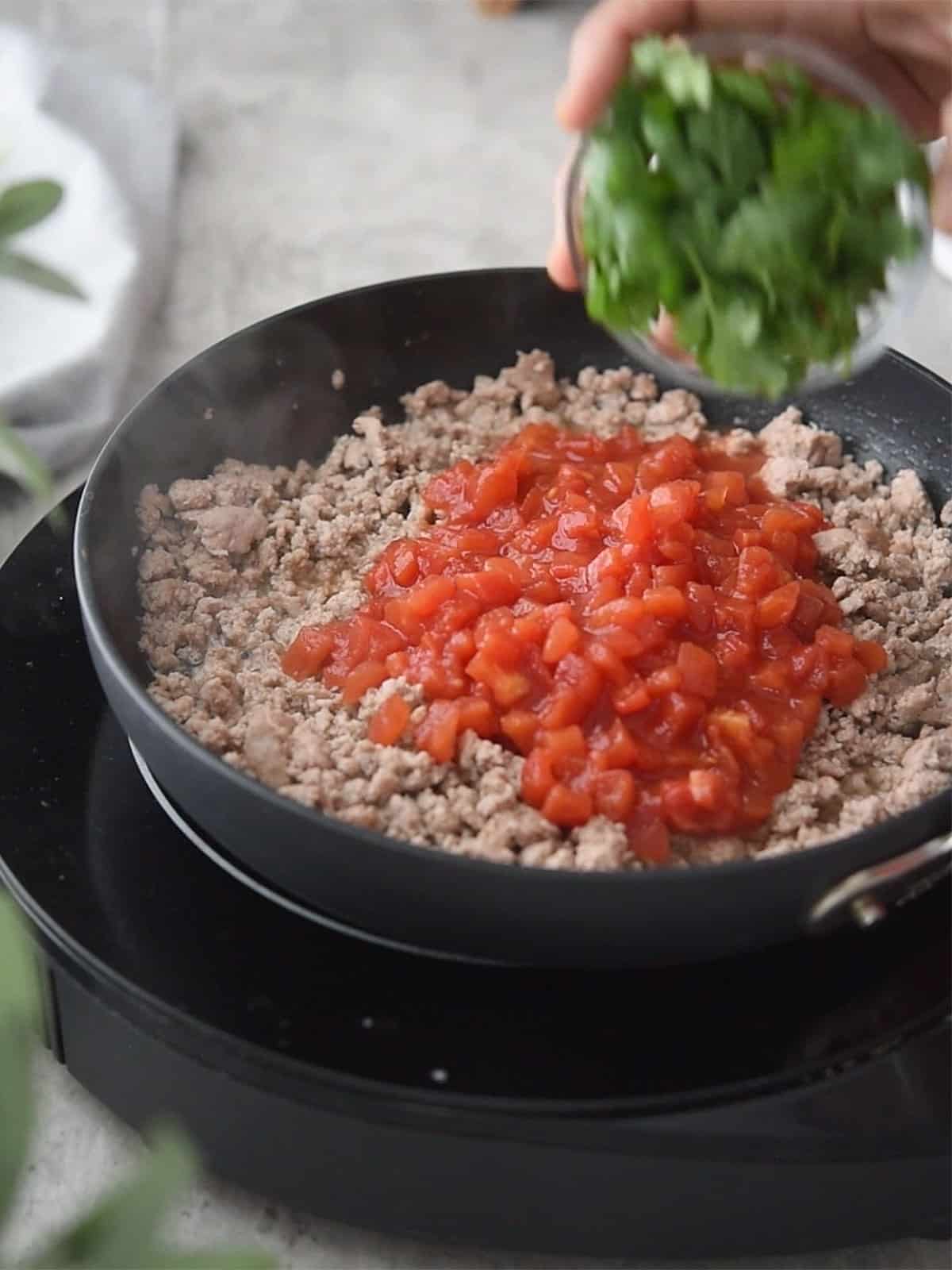 Cooking ground turkey in a pan until fully browned and cooked.