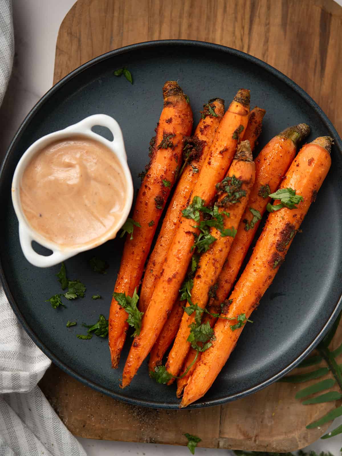 Plate of spicy roasted carrots garnished with fresh cilantro.