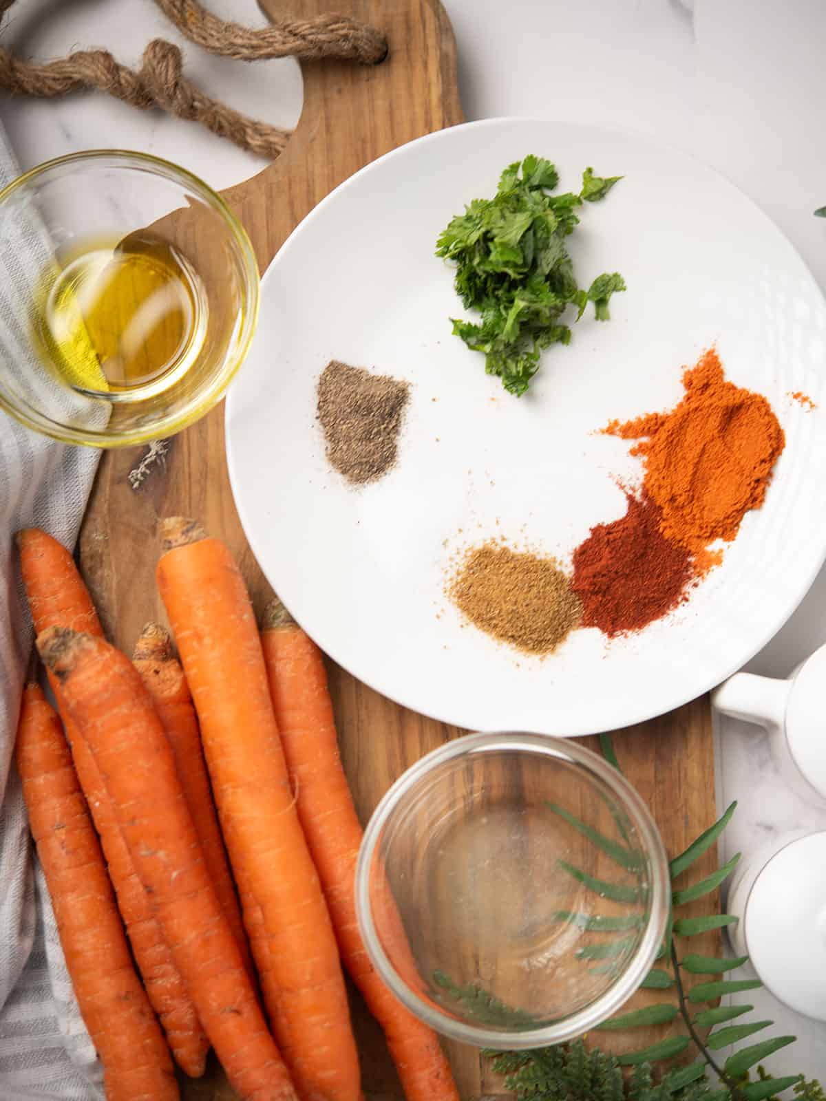 Ingredients for spicy roasted carrots: carrots, olive oil, spices, cilantro, and lemon.