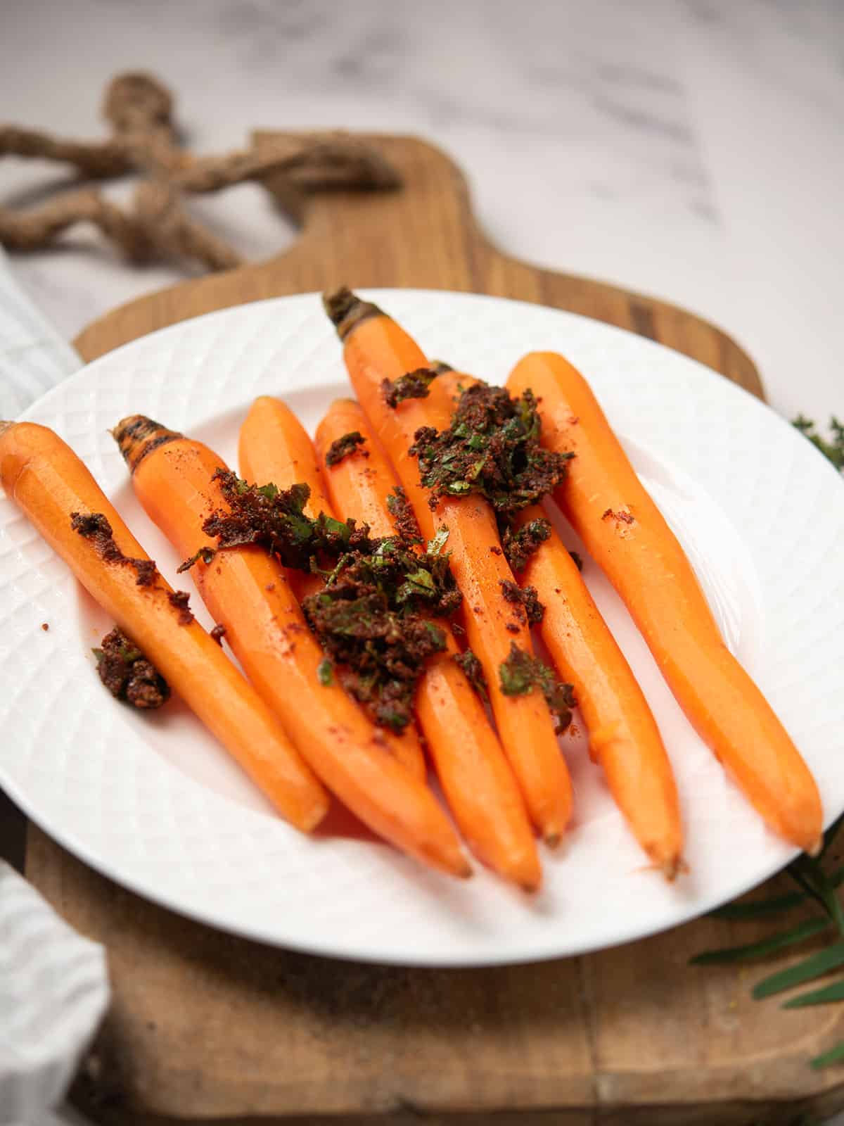 Mixing carrots with olive oil and spices.