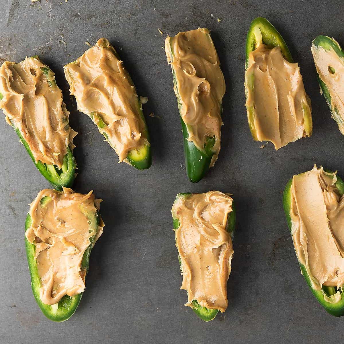 Filling jalapeno halves with peanut butter mixture
