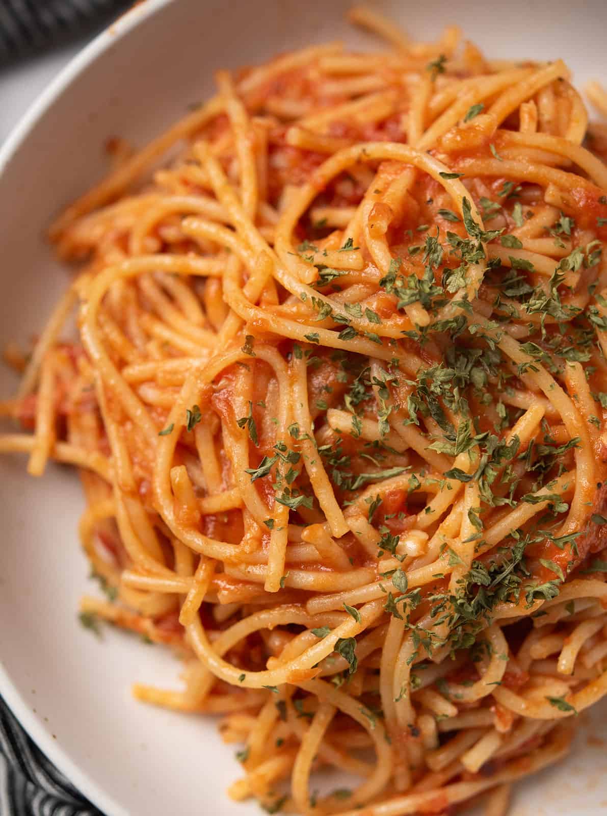 Close-up of spicy spaghetti topped with parsley.