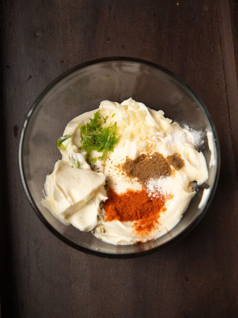 Adding mayonnaise and minced garlic in a small bowl.