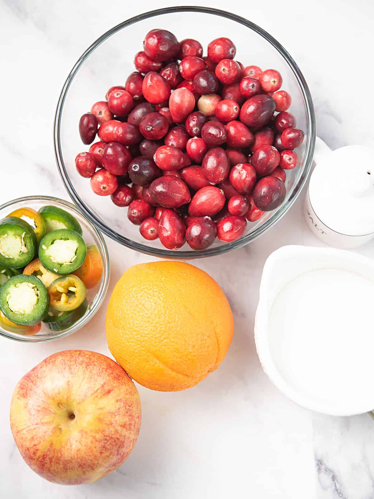 Ingredients for cranberry jalapeño relish including cranberries, jalapeños, cilantro, lime, and sugar.