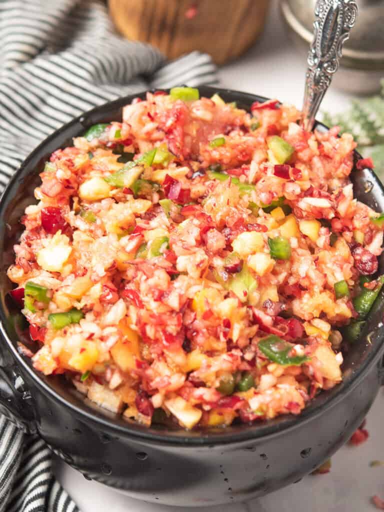 Fresh cranberry jalapeño relish served in a bowl, garnished with cilantro and lime.