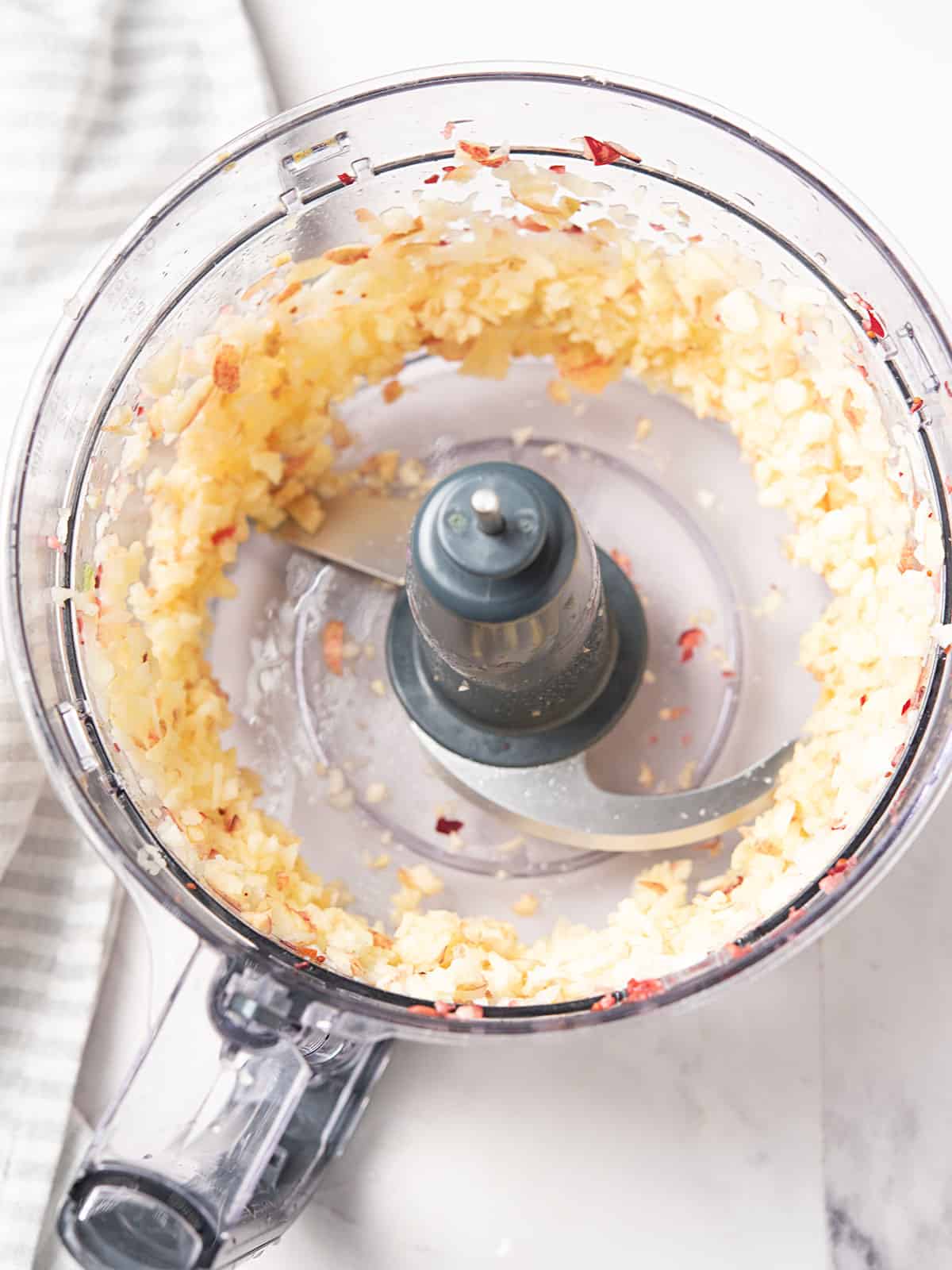 Fresh apple placed in a food processor.