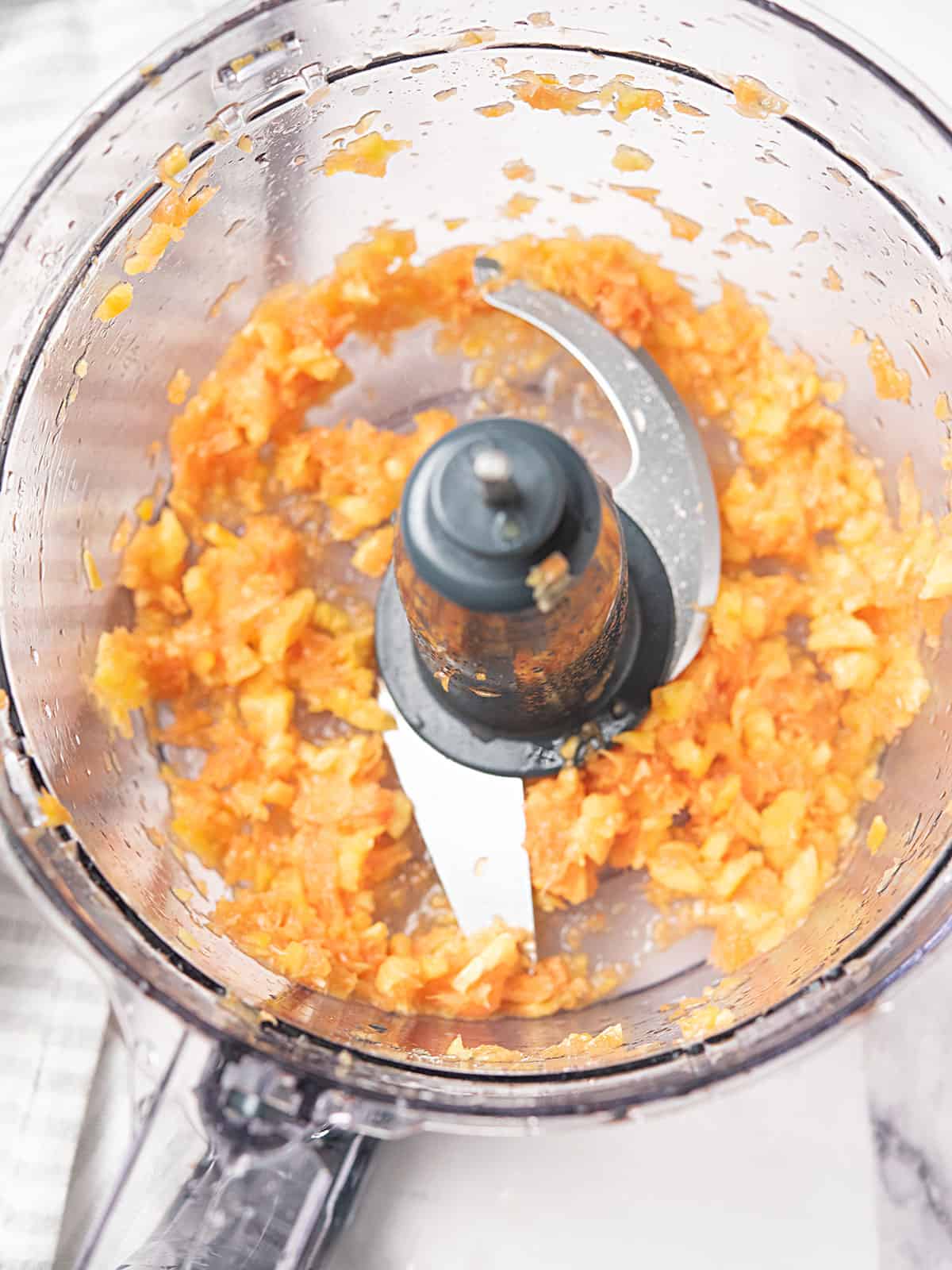 Fresh orange placed in a food processor.