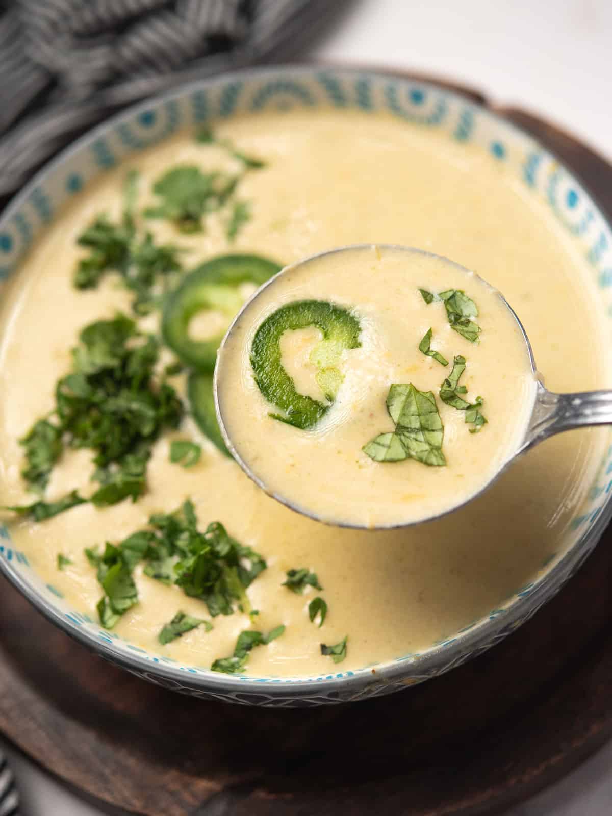 A spoon full of cream of jalapeño soup