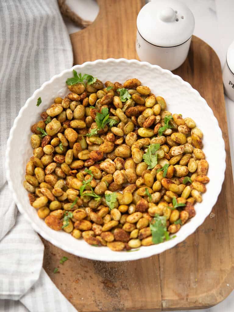 Bowl of roasted lima beans seasoned with spices and garnished with parsley