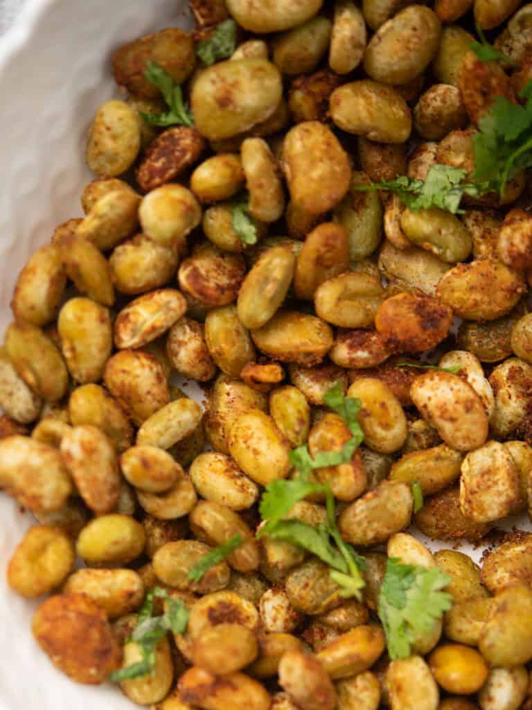 Close-up of golden roasted lima beans on a baking sheet.
