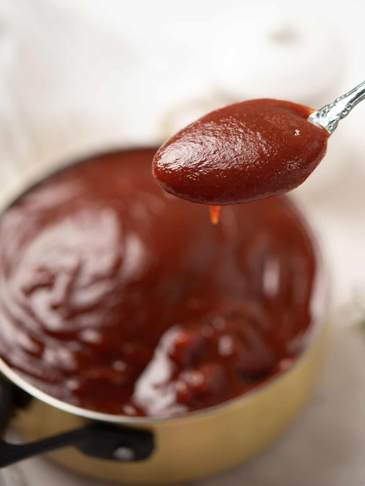 Homemade Sriracha BBQ Sauce in a bowl with ingredients.