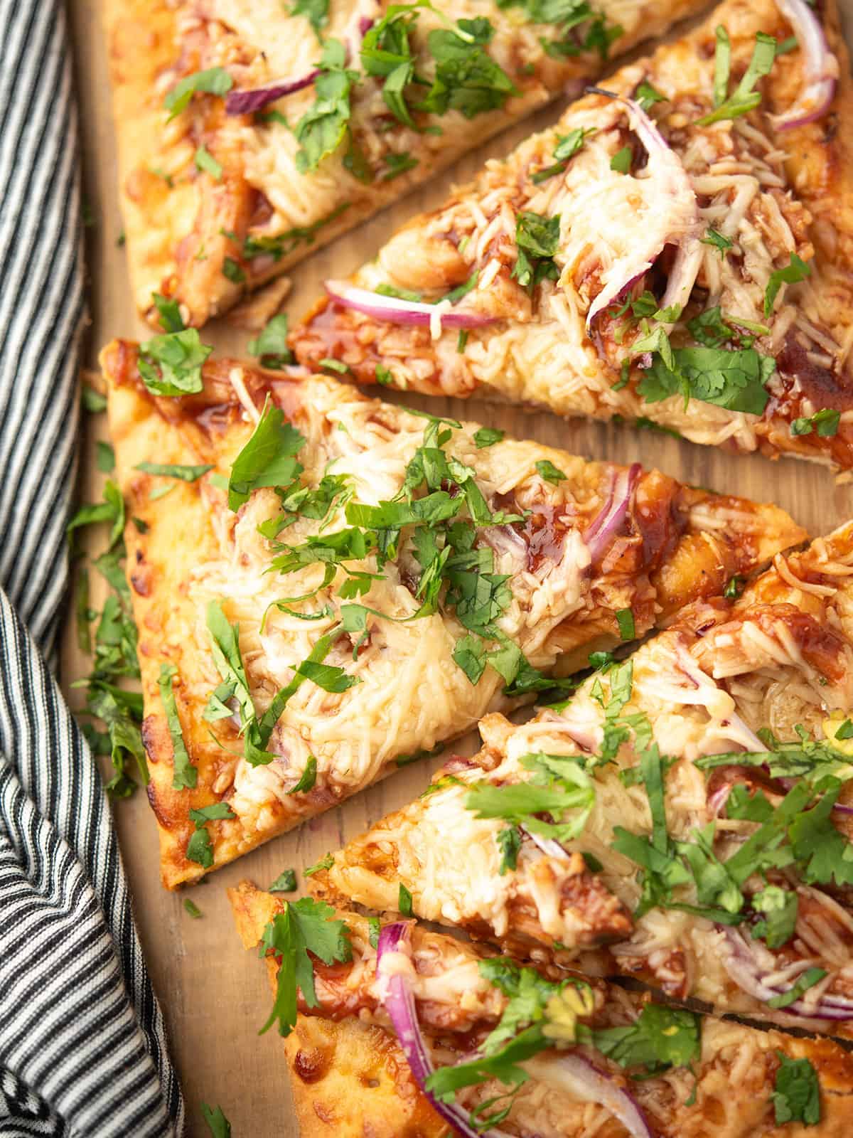 the sliced bbq chicken flatbread served over the wooden plank