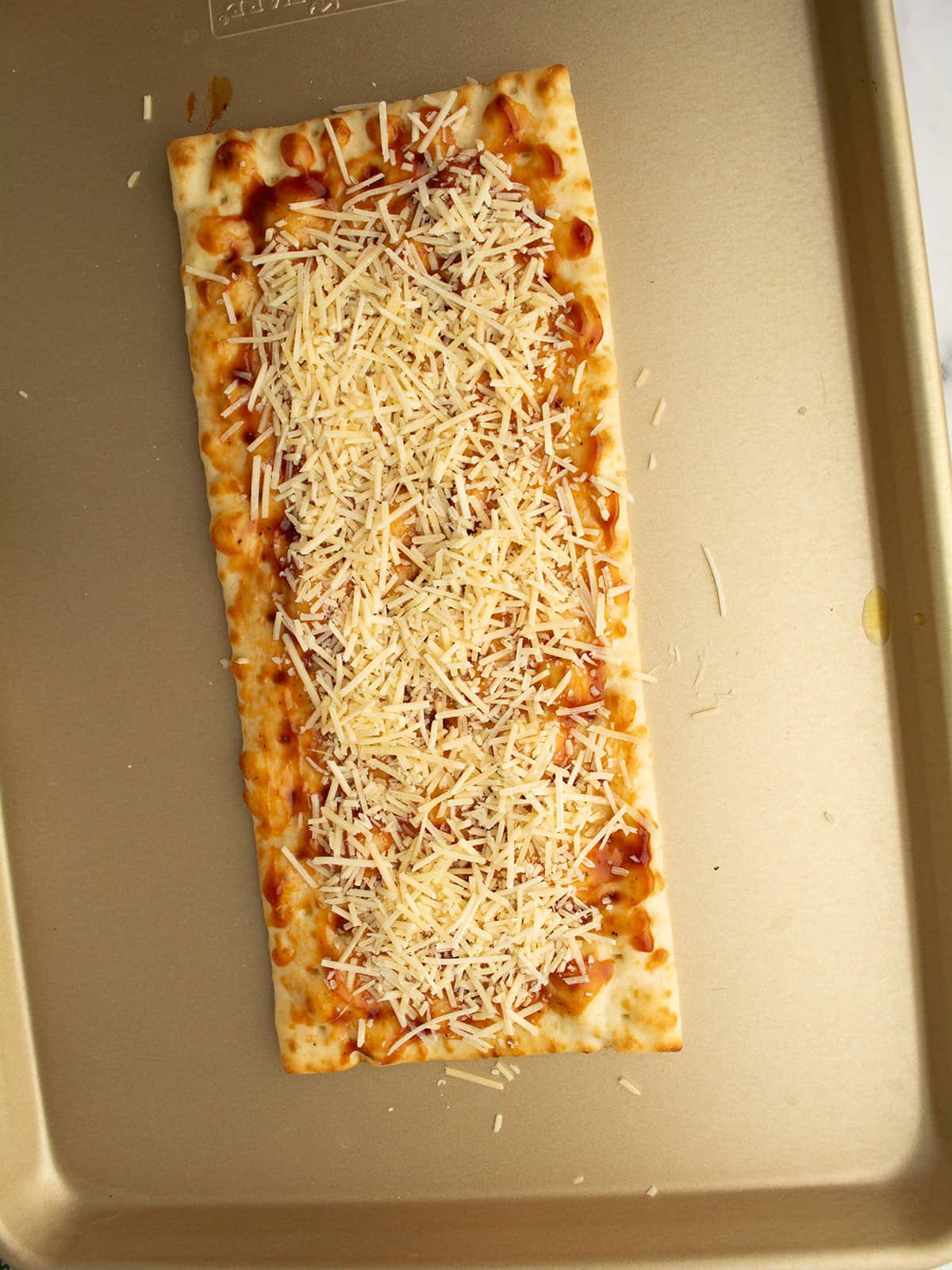 the cheese is spread over the flatbread