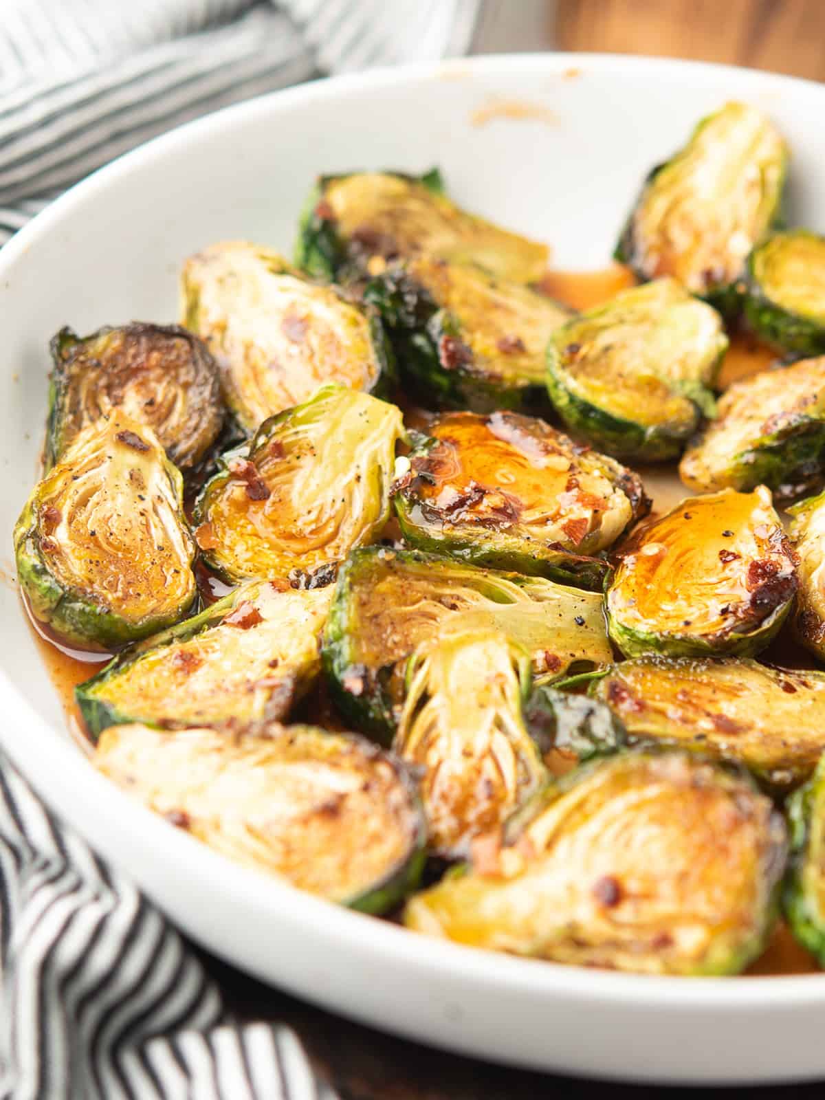 A close-up of crispy Hot Honey Brussels Sprouts on a plate.
