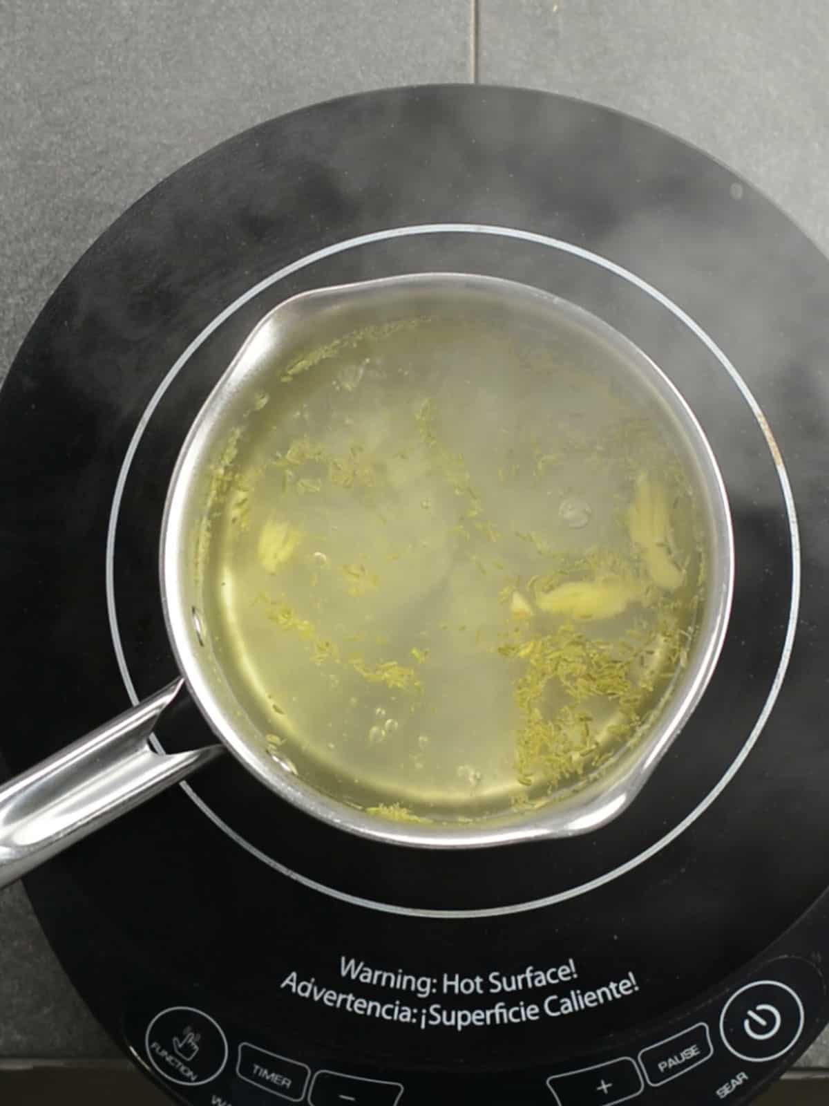 adding ginger and fennel seeds to the boiling water