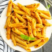 Instant Pot penne pasta coated with rich marinara sauce with fresh basil leaves as garnish
