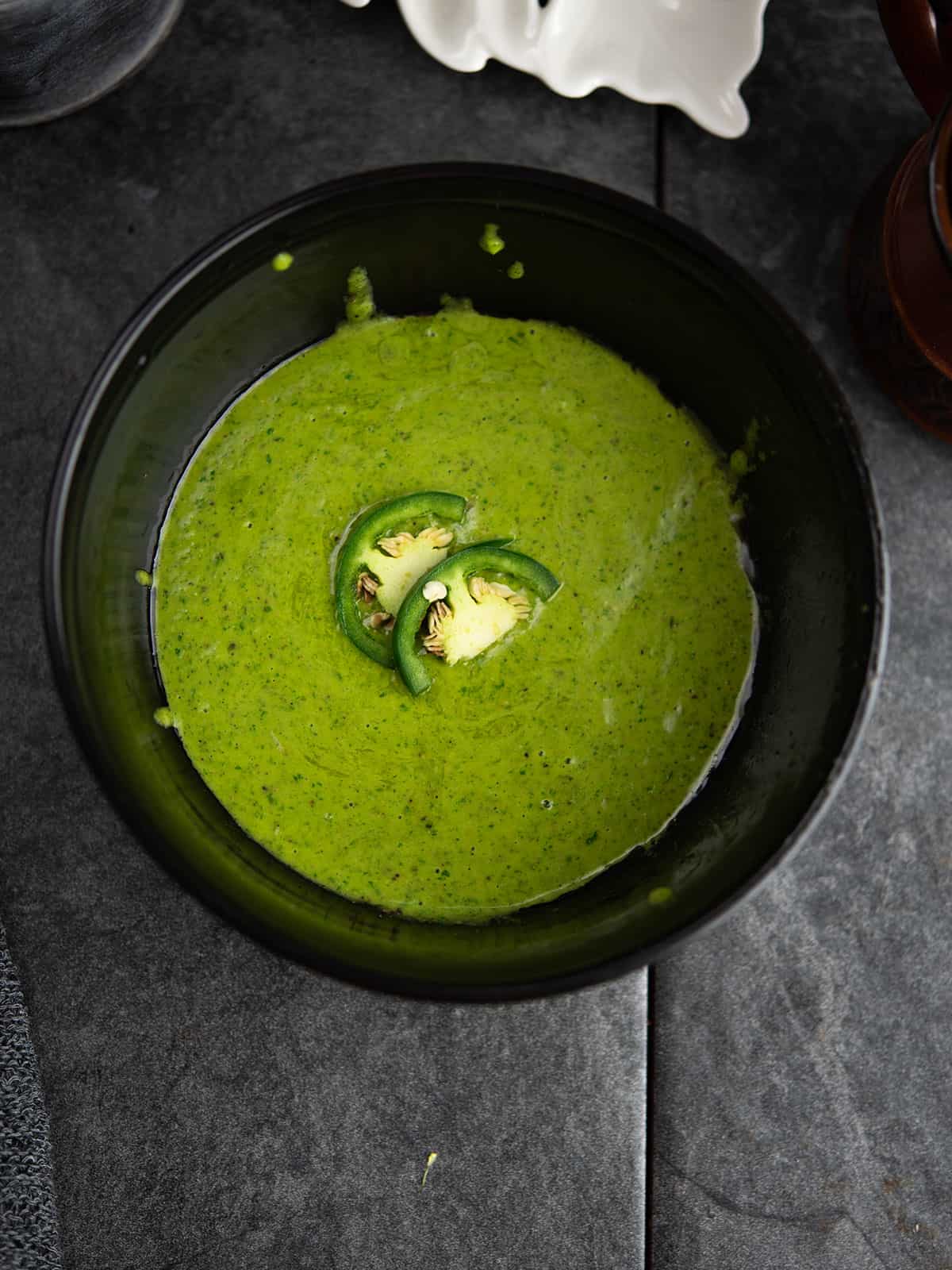 jalapeno vinaigrette in a black bowl garnished with jalapeno slices