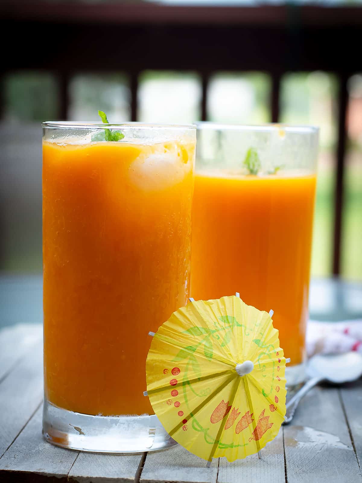 two glasses of mango juice with drink decors