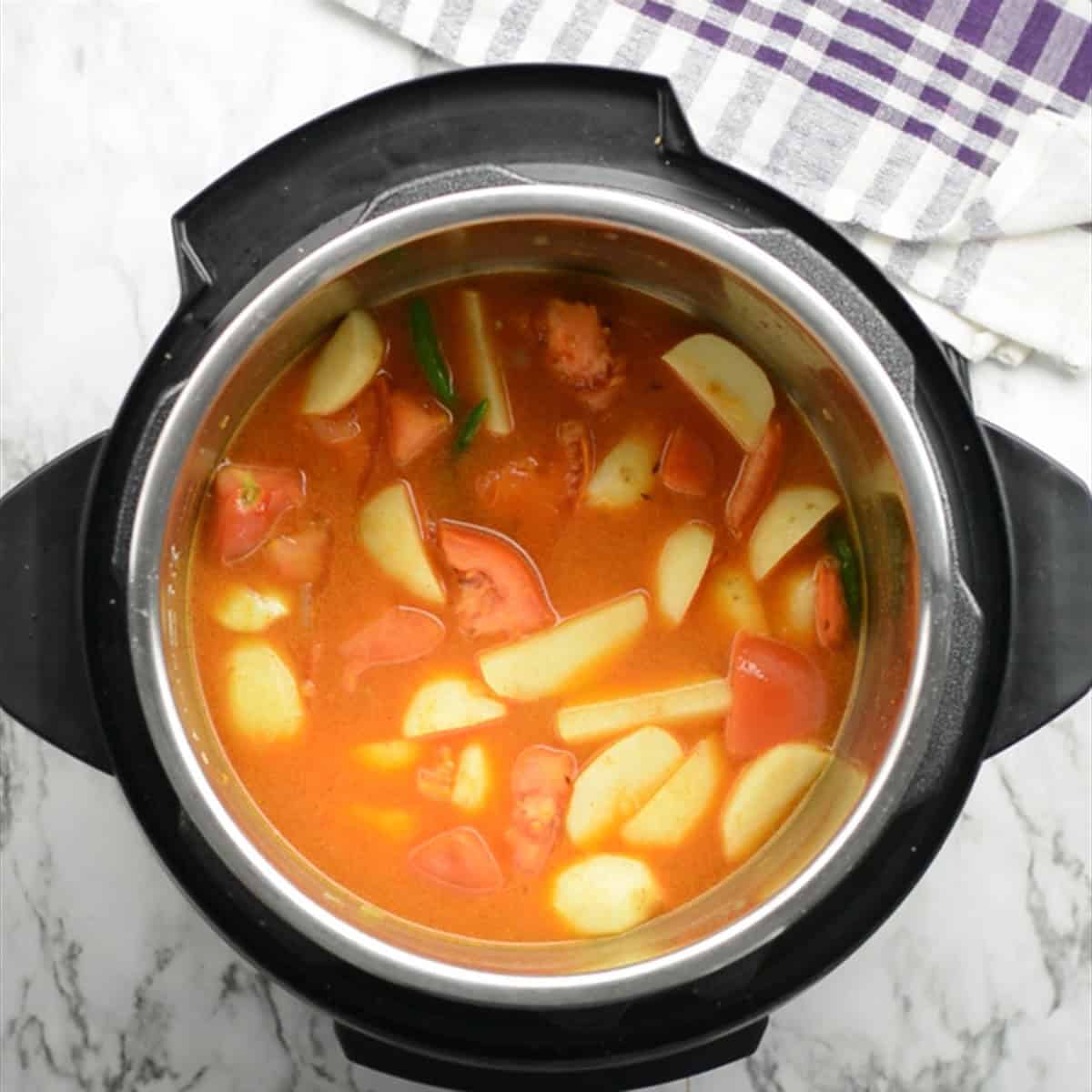 adding water to cook the potato curry in the Instant Pot
