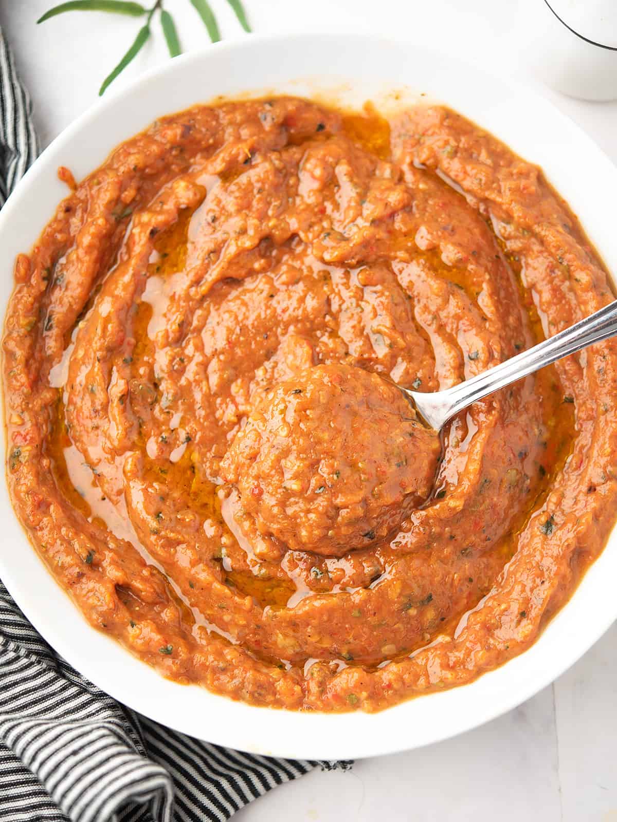 Close-up of roasted veggies sauce with a spoon, ready to serve.
