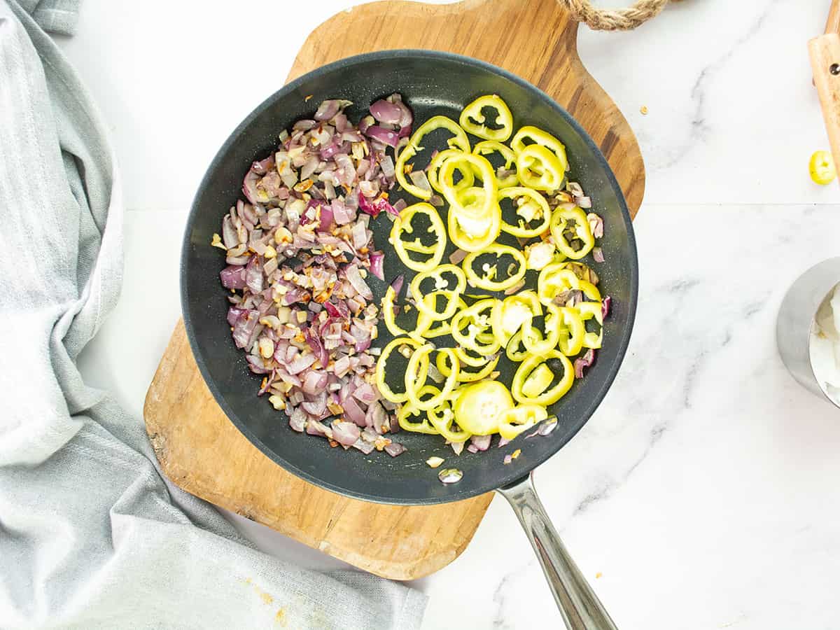Chopped banana peppers added to the onion and garlic mixture