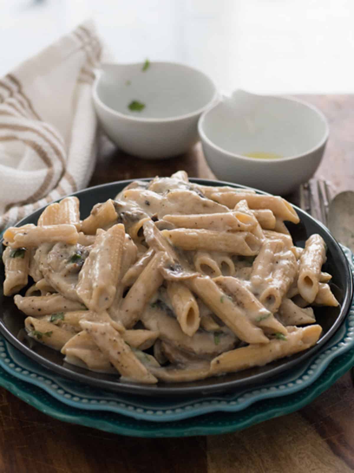 cream of mushroom pasta sauce in pasta bowl placed over dinner table.