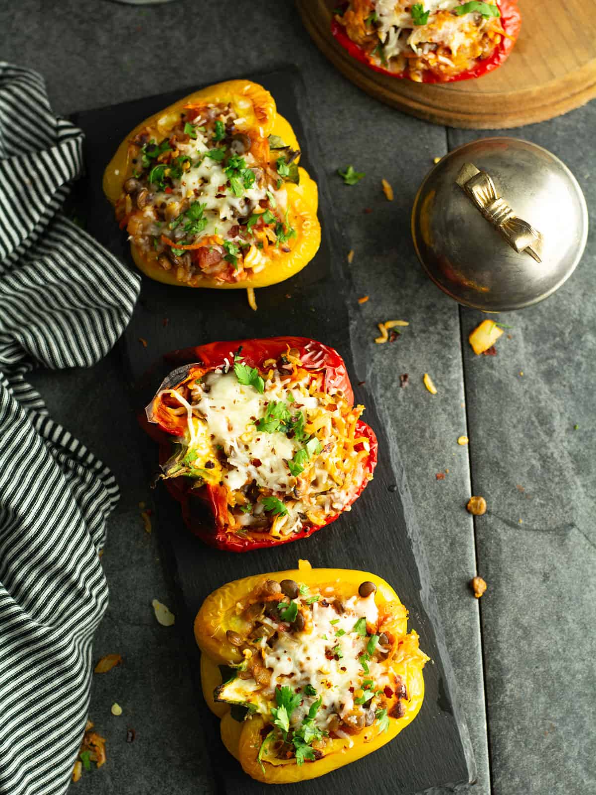lentil stuffed peppers served over the dinner table, garnished with chopped fresh cilantro