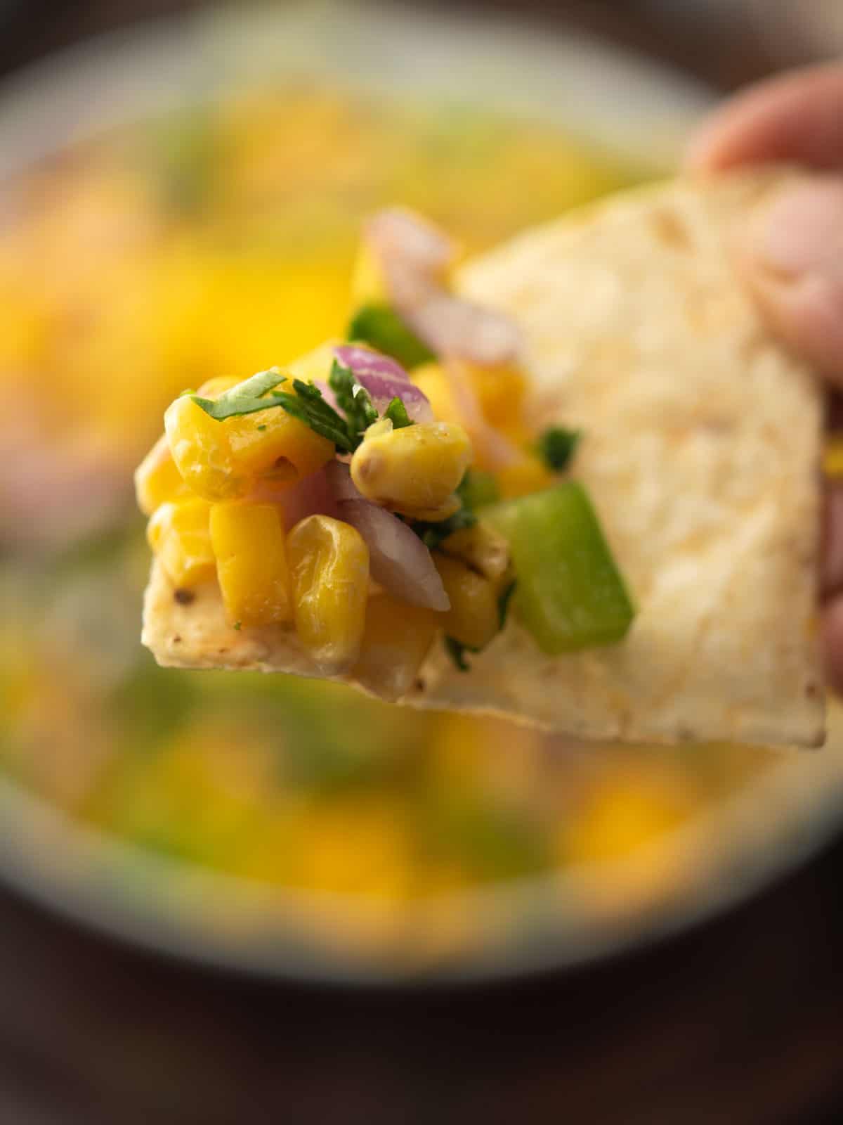 mango corn salsa scooped in the chips