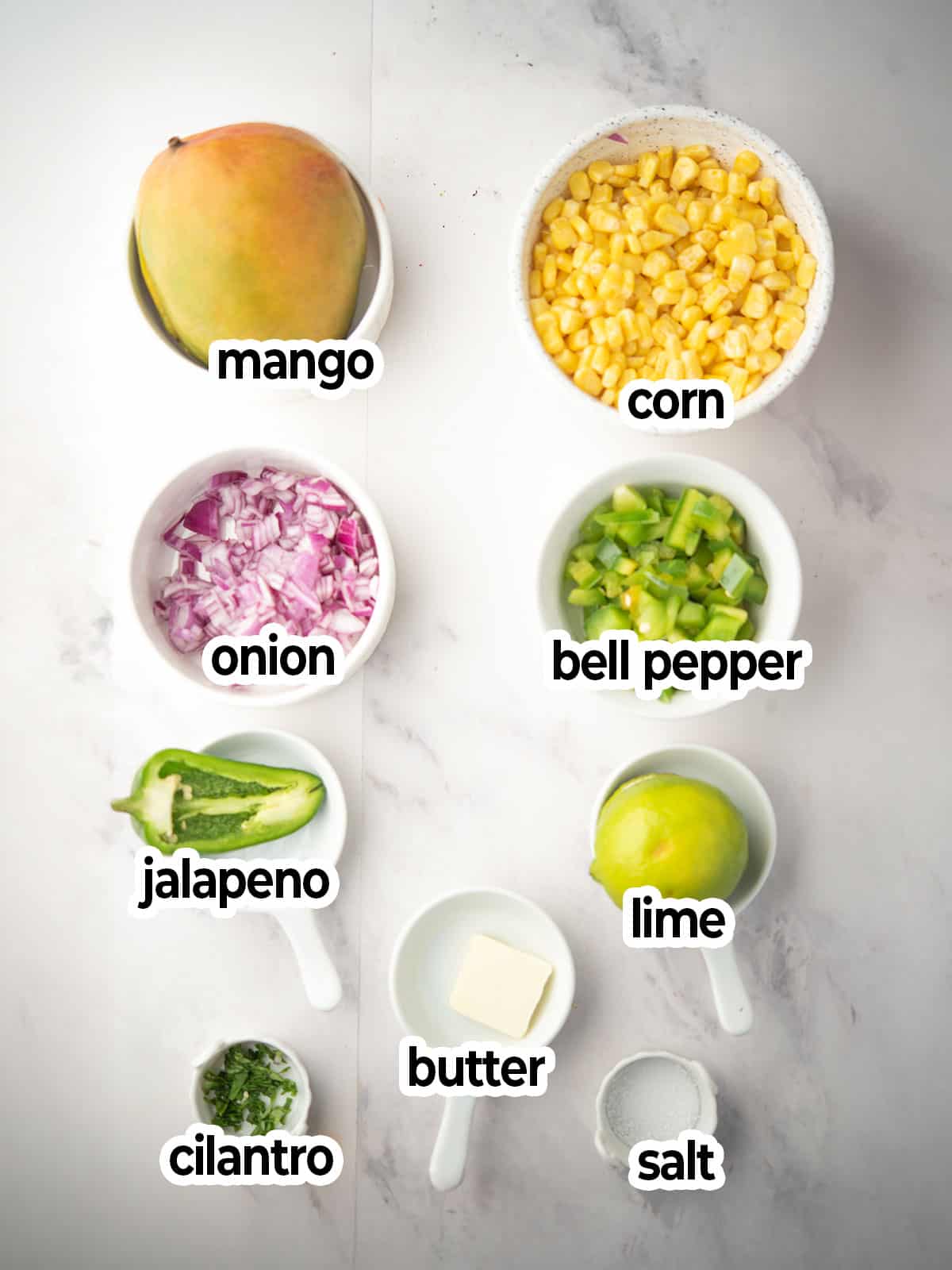 Fresh ingredients for mango corn salsa: mango, corn, bell pepper, onion, jalapeño, cilantro.