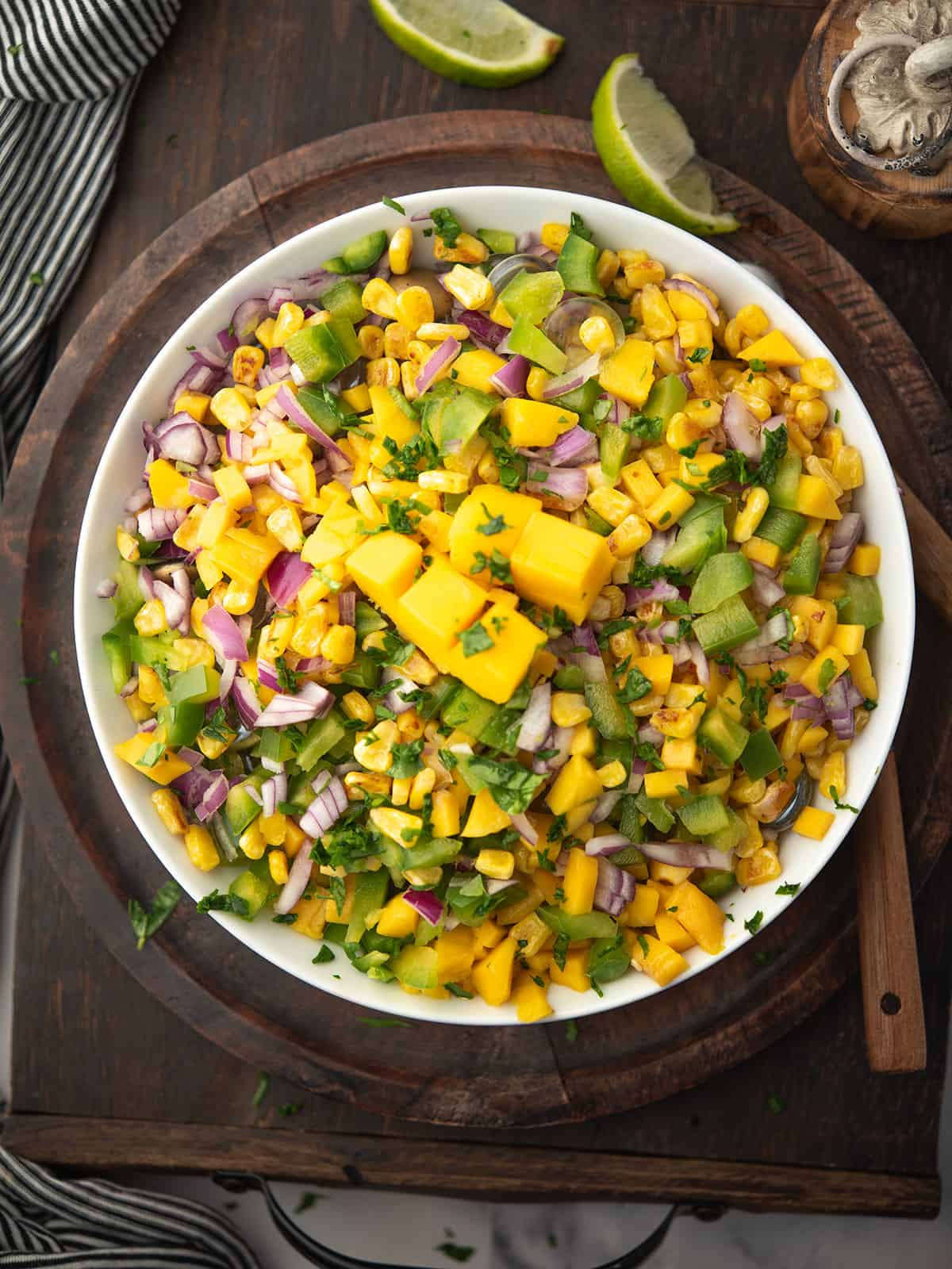 Bright and colorful bowl of mango corn salsa topped with cilantro.
