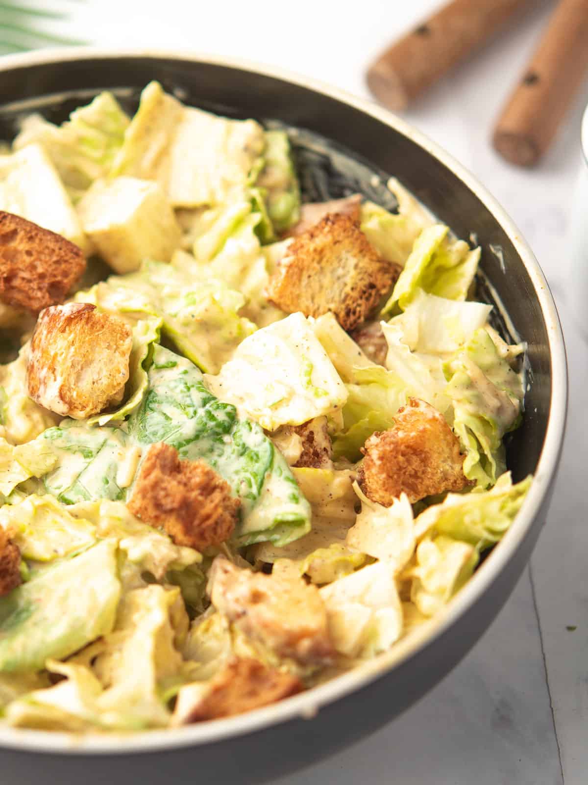 Close-up of Spicy Caesar Salad topped with jalapeños and spicy dressing.