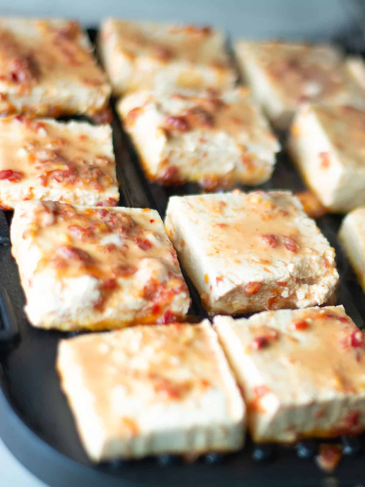 grilling spicy marinated tofu cubes
