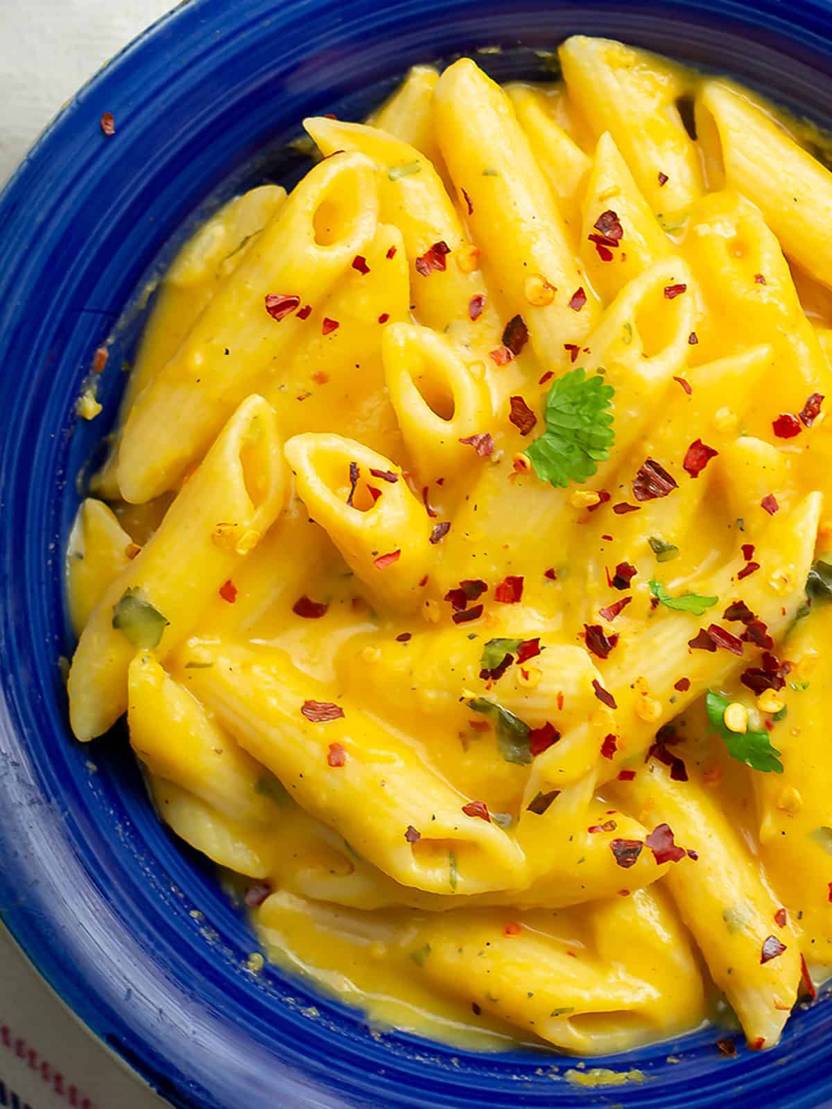 Smooth and creamy sweet potato pasta sauce in a bowl garnished with crushed red pepper.