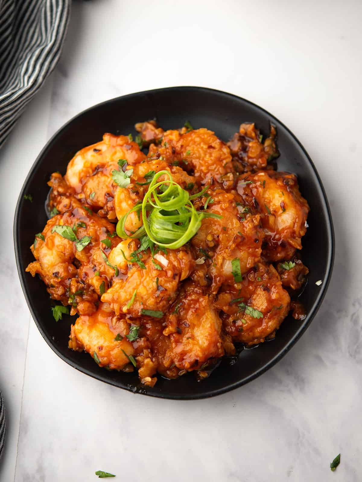 Spicy volcano shrimp served on a plate with garnish