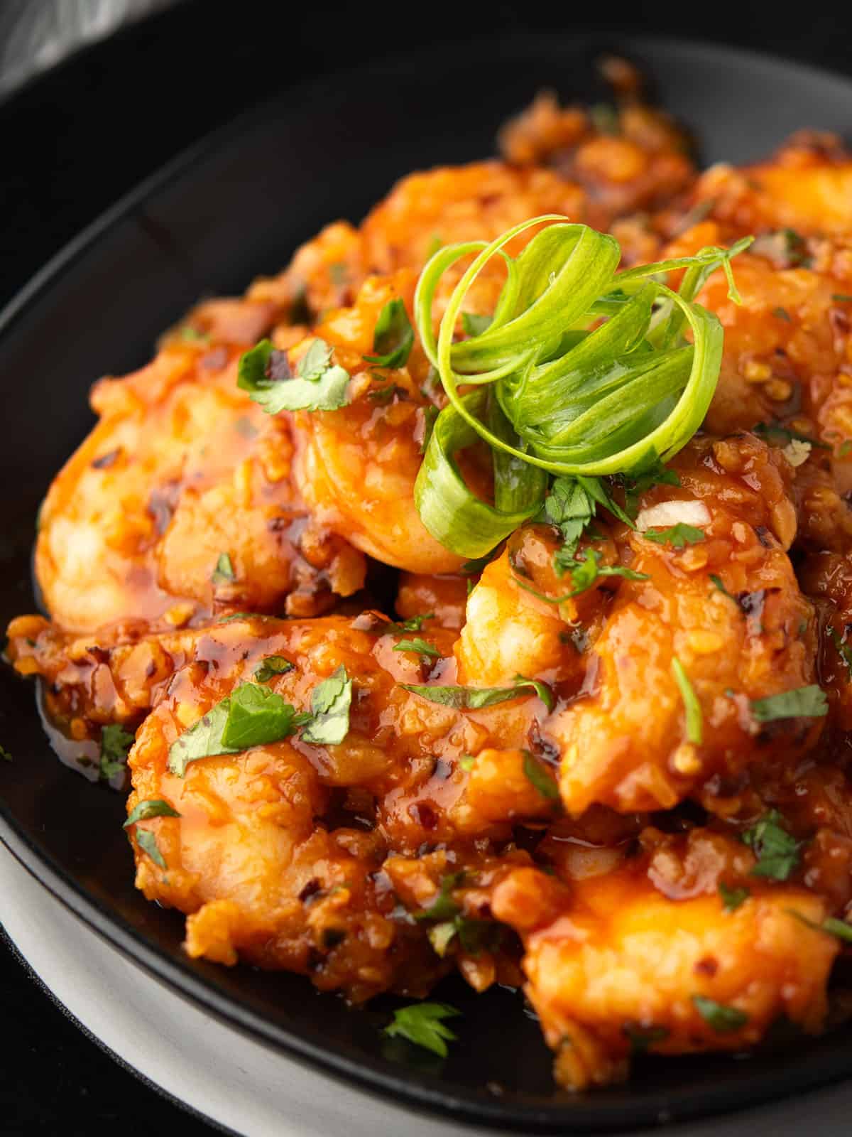 Close-up of crispy shrimp coated in creamy spicy sauce